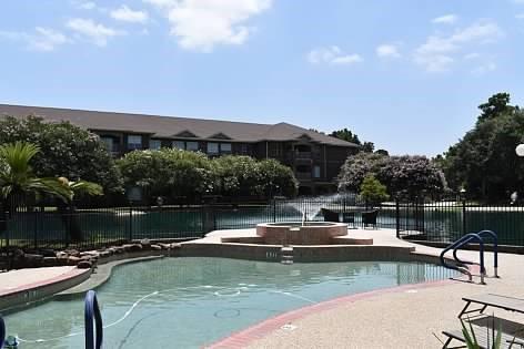 view of pool with a patio area, a hot tub, and a water view