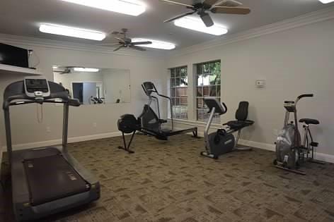 workout area with crown molding, dark carpet, and ceiling fan