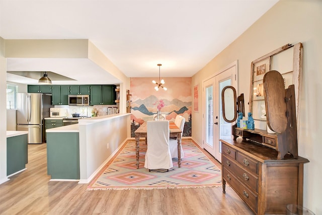 dining room with an inviting chandelier and light hardwood / wood-style flooring