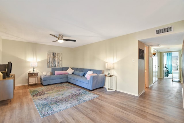 living room featuring hardwood / wood-style floors and ceiling fan