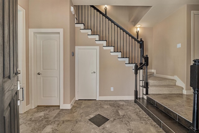 entrance foyer featuring baseboards and stairs