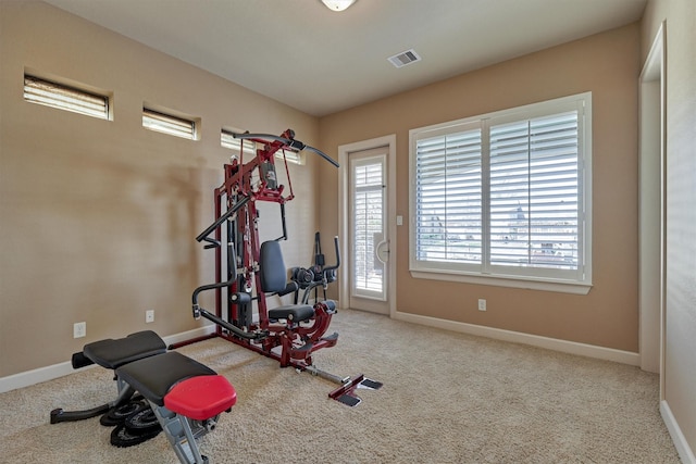 exercise area with carpet floors, visible vents, and baseboards