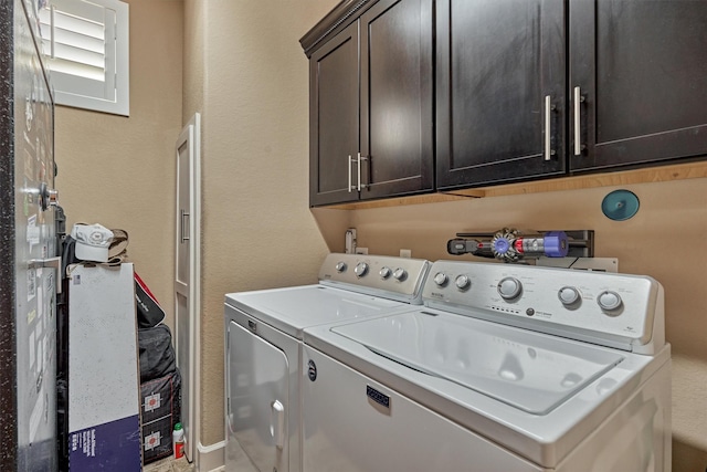 washroom featuring separate washer and dryer and cabinet space