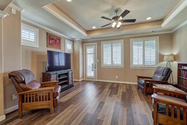 sitting room with visible vents, crown molding, a tray ceiling, and wood finished floors