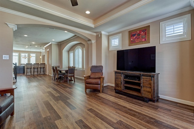 sitting room featuring arched walkways, recessed lighting, ornamental molding, wood finished floors, and baseboards