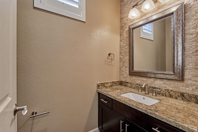 bathroom with a textured wall and vanity