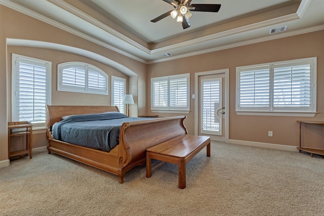 bedroom featuring a tray ceiling, visible vents, carpet flooring, and multiple windows