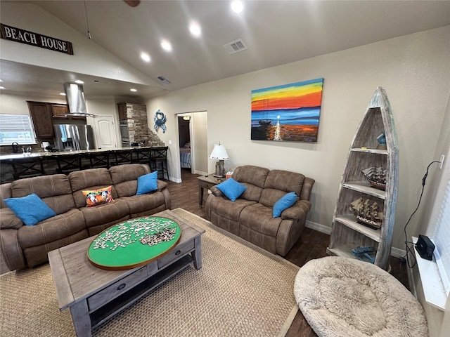 living room with sink, light hardwood / wood-style floors, and high vaulted ceiling