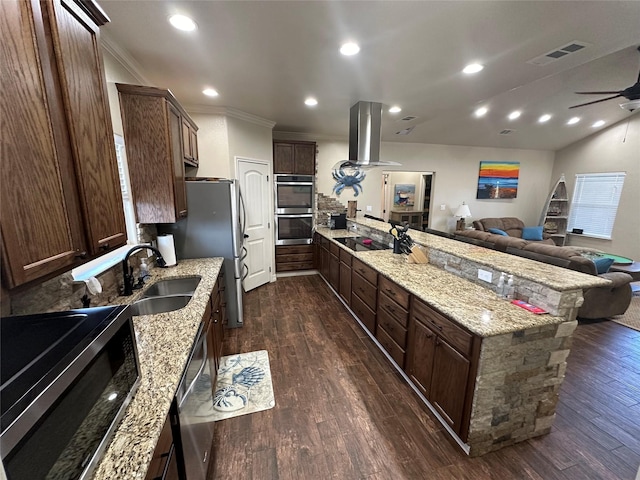 kitchen featuring sink, stainless steel appliances, island range hood, light stone countertops, and dark hardwood / wood-style flooring