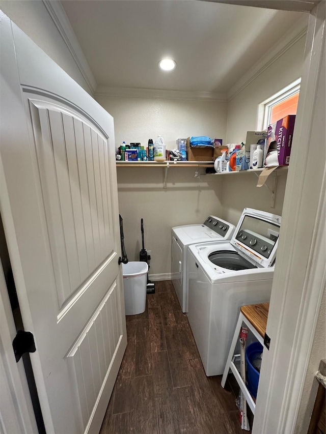 laundry area featuring crown molding, washer and dryer, and dark hardwood / wood-style flooring