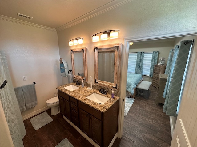 bathroom featuring vanity, hardwood / wood-style flooring, ornamental molding, and toilet