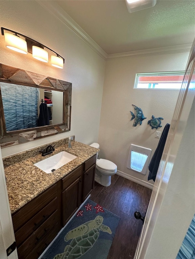 bathroom with ornamental molding, hardwood / wood-style floors, vanity, and toilet