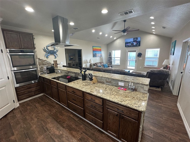 kitchen featuring island exhaust hood, light stone countertops, black electric stovetop, and dark hardwood / wood-style flooring