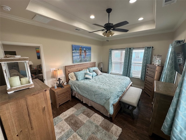 bedroom featuring dark hardwood / wood-style floors, ornamental molding, and a raised ceiling