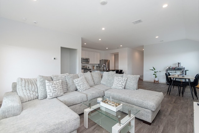 living room featuring wood-type flooring and vaulted ceiling