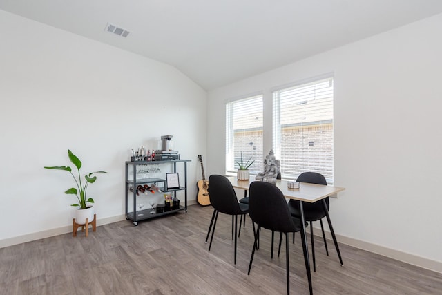 dining room with lofted ceiling and wood-type flooring