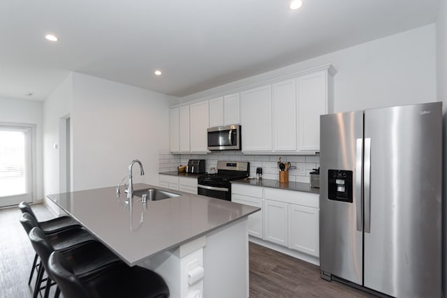 kitchen featuring a kitchen island with sink, sink, white cabinets, and appliances with stainless steel finishes