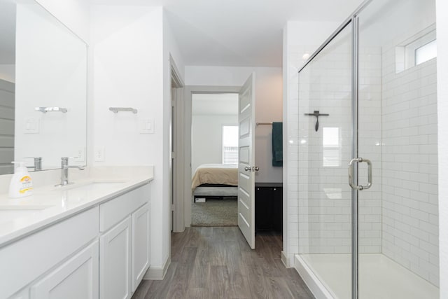 bathroom featuring vanity, hardwood / wood-style flooring, and a shower with shower door