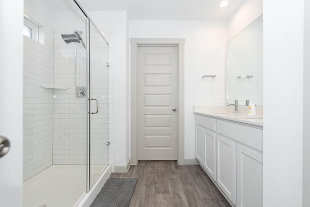 bathroom featuring hardwood / wood-style flooring, vanity, and an enclosed shower