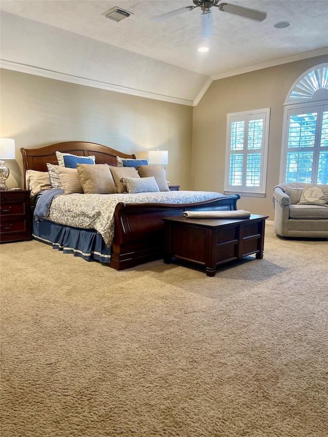 bedroom featuring light carpet, visible vents, lofted ceiling, ceiling fan, and ornamental molding