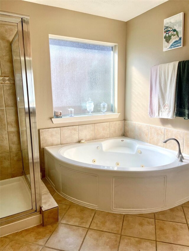 bathroom with a whirlpool tub, a stall shower, and tile patterned floors