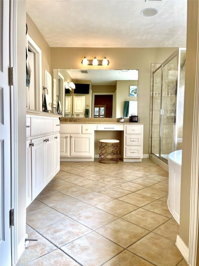 full bath with a shower stall, a textured ceiling, tile patterned flooring, and vanity