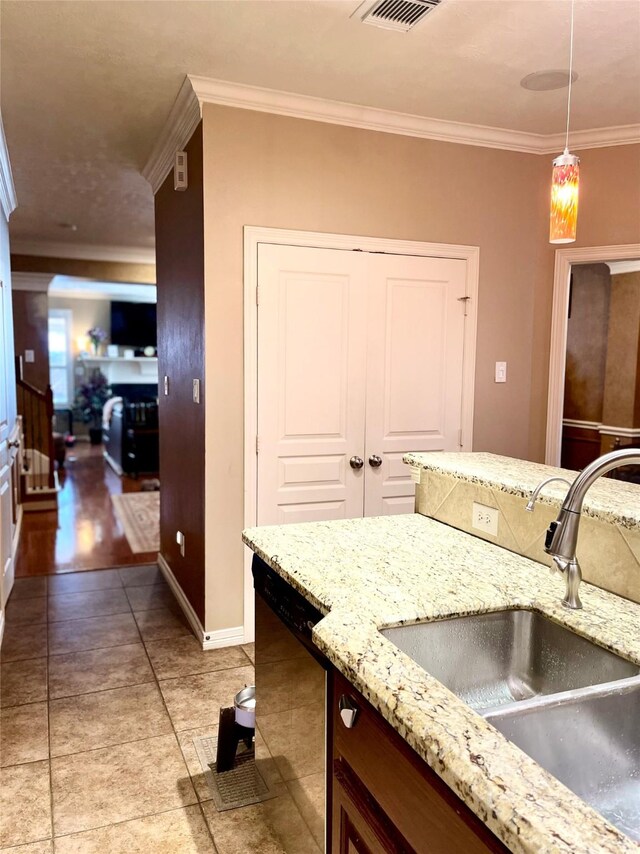 kitchen with a sink, baseboards, ornamental molding, dishwasher, and decorative light fixtures