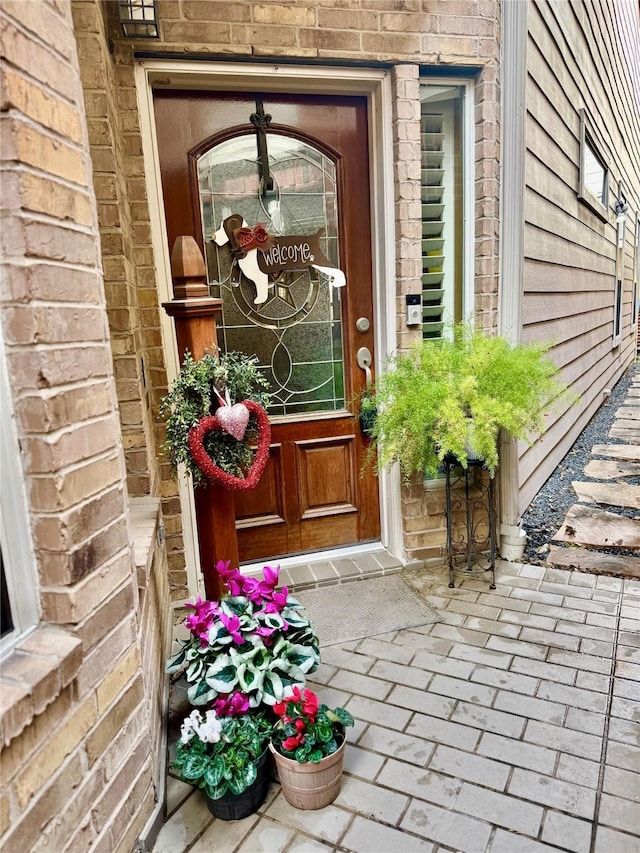 view of exterior entry with brick siding