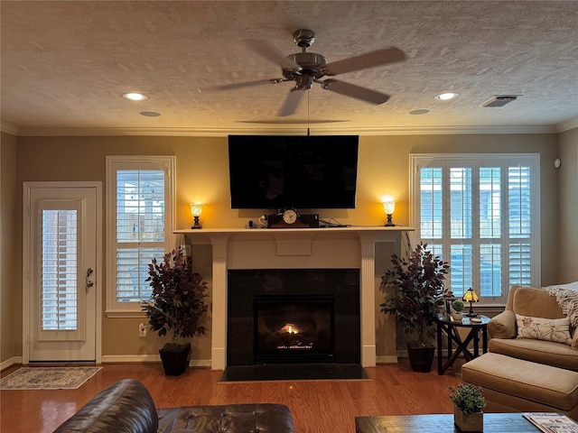 living area featuring ornamental molding, plenty of natural light, and wood finished floors