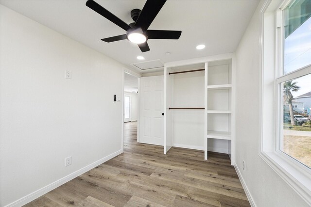 unfurnished bedroom featuring multiple windows, ceiling fan, and light wood-type flooring