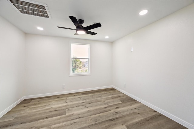 empty room with baseboards, visible vents, wood finished floors, and recessed lighting