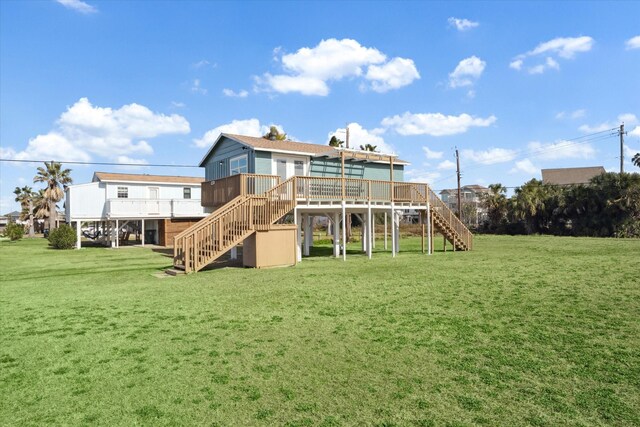 rear view of house with a wooden deck and a lawn