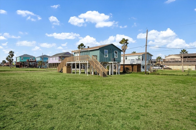 rear view of property with a wooden deck and a lawn