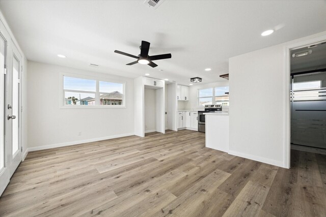 unfurnished living room with ceiling fan and light wood-type flooring