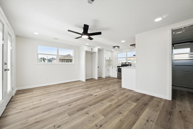 unfurnished living room with baseboards, recessed lighting, and light wood-style floors