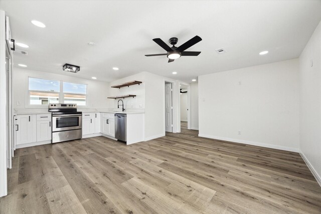 kitchen with appliances with stainless steel finishes, sink, white cabinets, ceiling fan, and light wood-type flooring