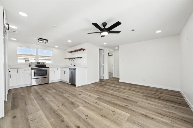 kitchen with recessed lighting, light wood-style floors, light countertops, appliances with stainless steel finishes, and open shelves