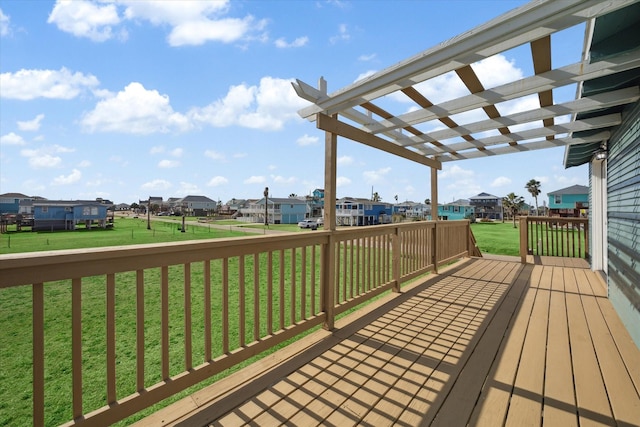 wooden terrace with a residential view, a lawn, and a pergola