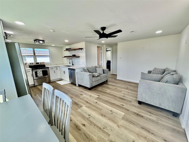 living room with baseboards, light wood finished floors, visible vents, and recessed lighting