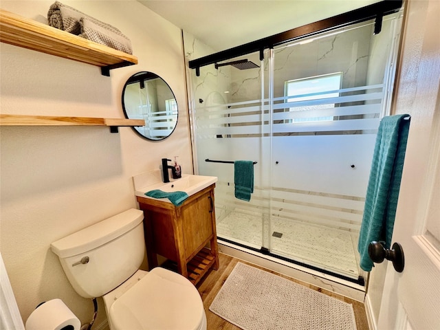 full bathroom with toilet, a shower stall, wood finished floors, and vanity