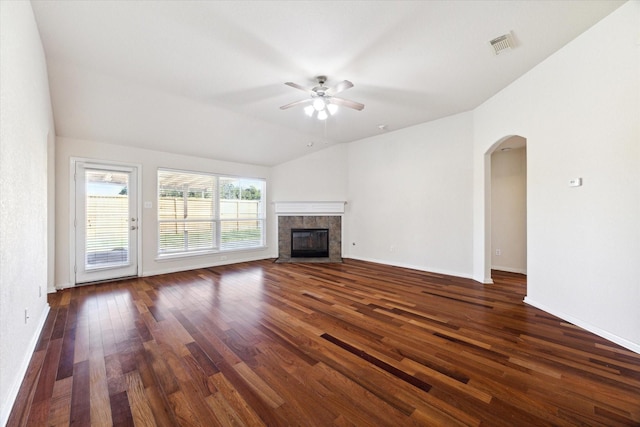 unfurnished living room featuring a tiled fireplace, ceiling fan, lofted ceiling, and dark hardwood / wood-style flooring