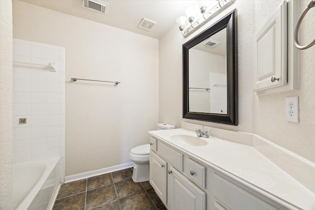 full bathroom with vanity, tiled shower / bath combo, and toilet