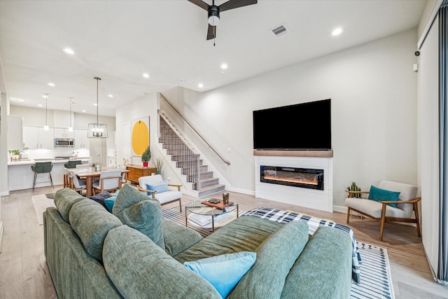 living room with ceiling fan and light hardwood / wood-style floors