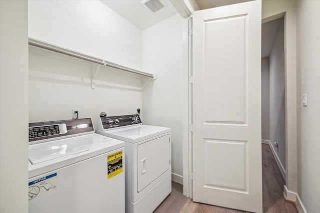 laundry area featuring hardwood / wood-style flooring and washer and dryer