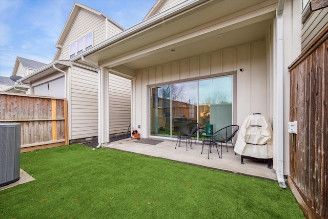 back of property featuring a yard, cooling unit, and a patio area