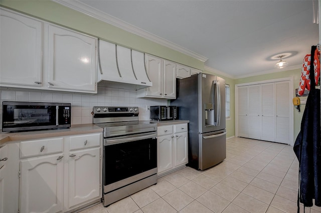 kitchen featuring light tile patterned floors, ornamental molding, stainless steel appliances, decorative backsplash, and white cabinets