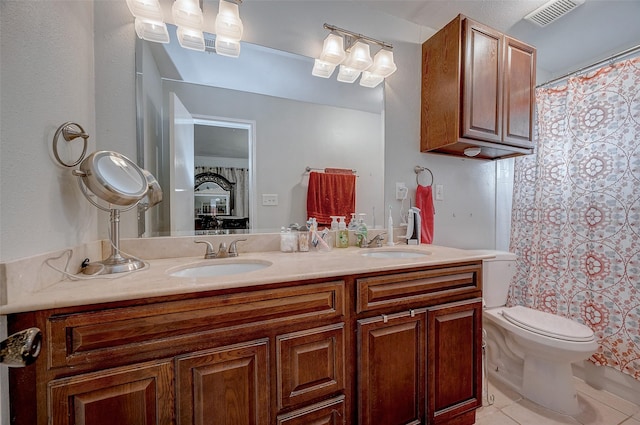 bathroom with tile patterned flooring, vanity, and toilet