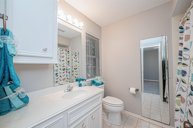 bathroom featuring vanity, tile patterned floors, and toilet