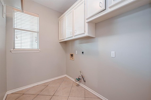 washroom with gas dryer hookup, cabinets, washer hookup, light tile patterned floors, and hookup for an electric dryer