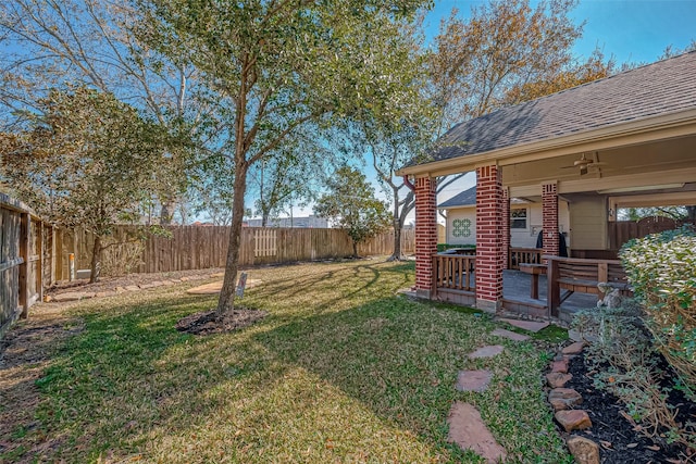 view of yard featuring a wooden deck and ceiling fan